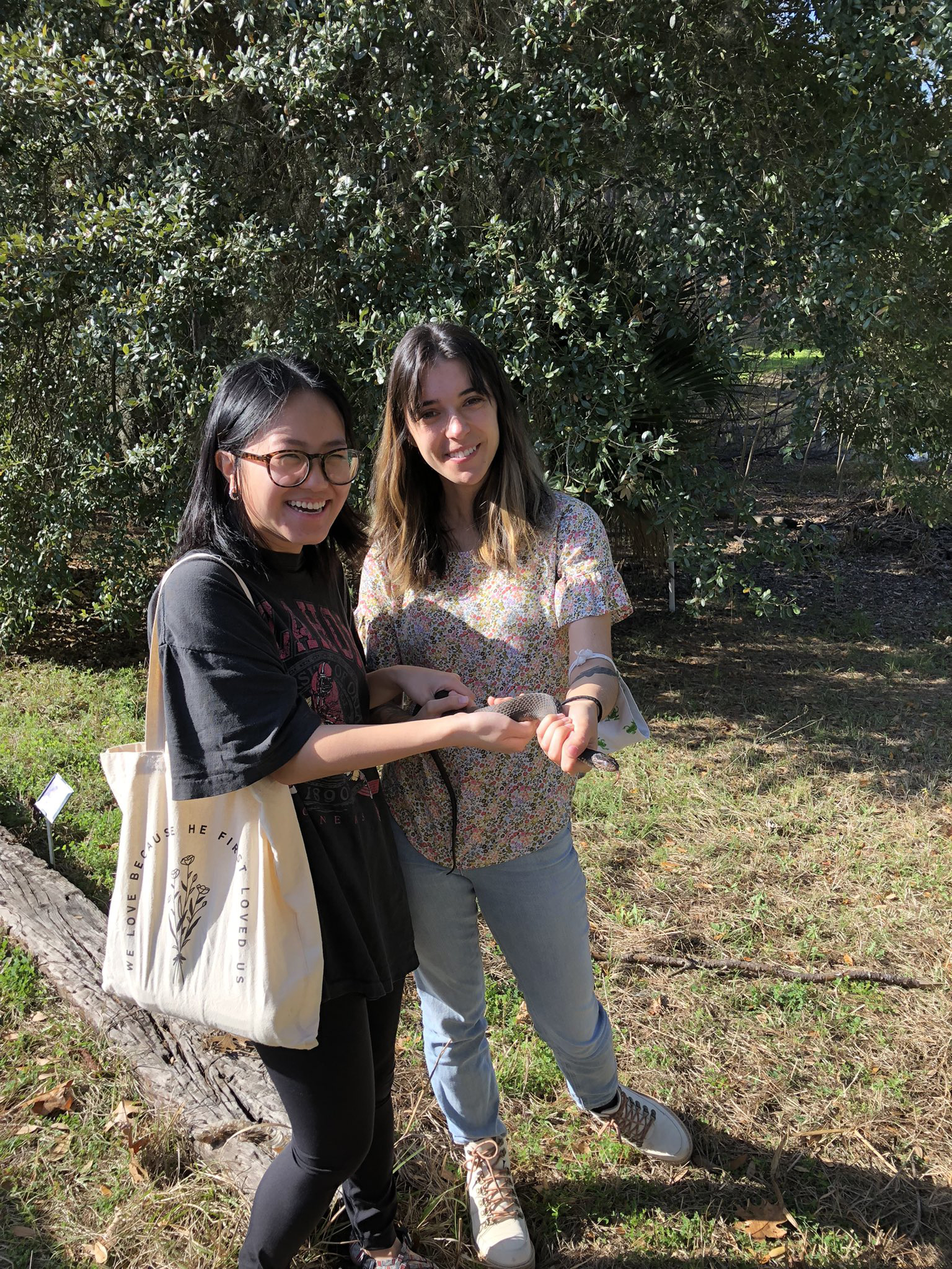 Two participants holding a snake they found on a walk around campus!